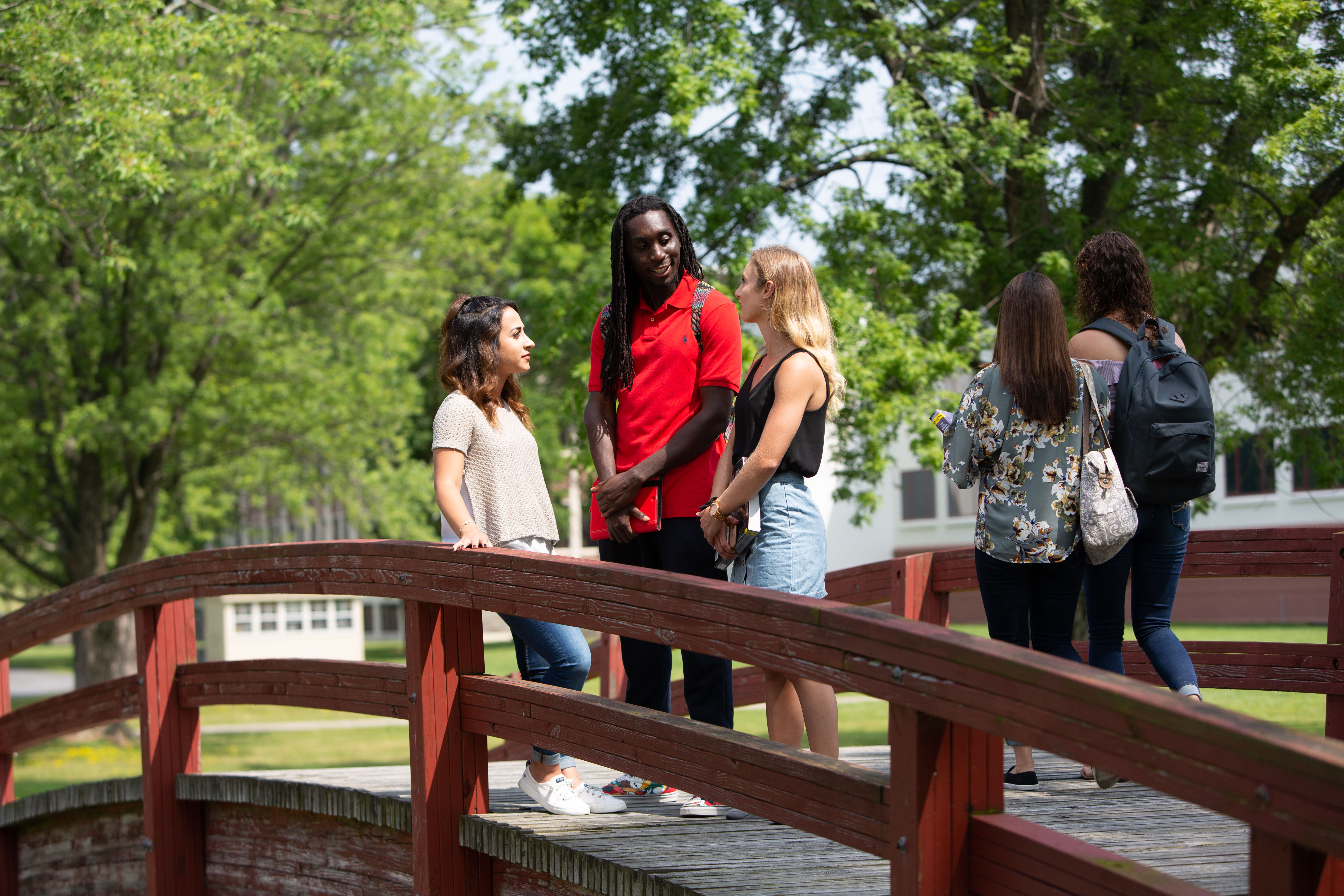 students talking on a bridge on campus